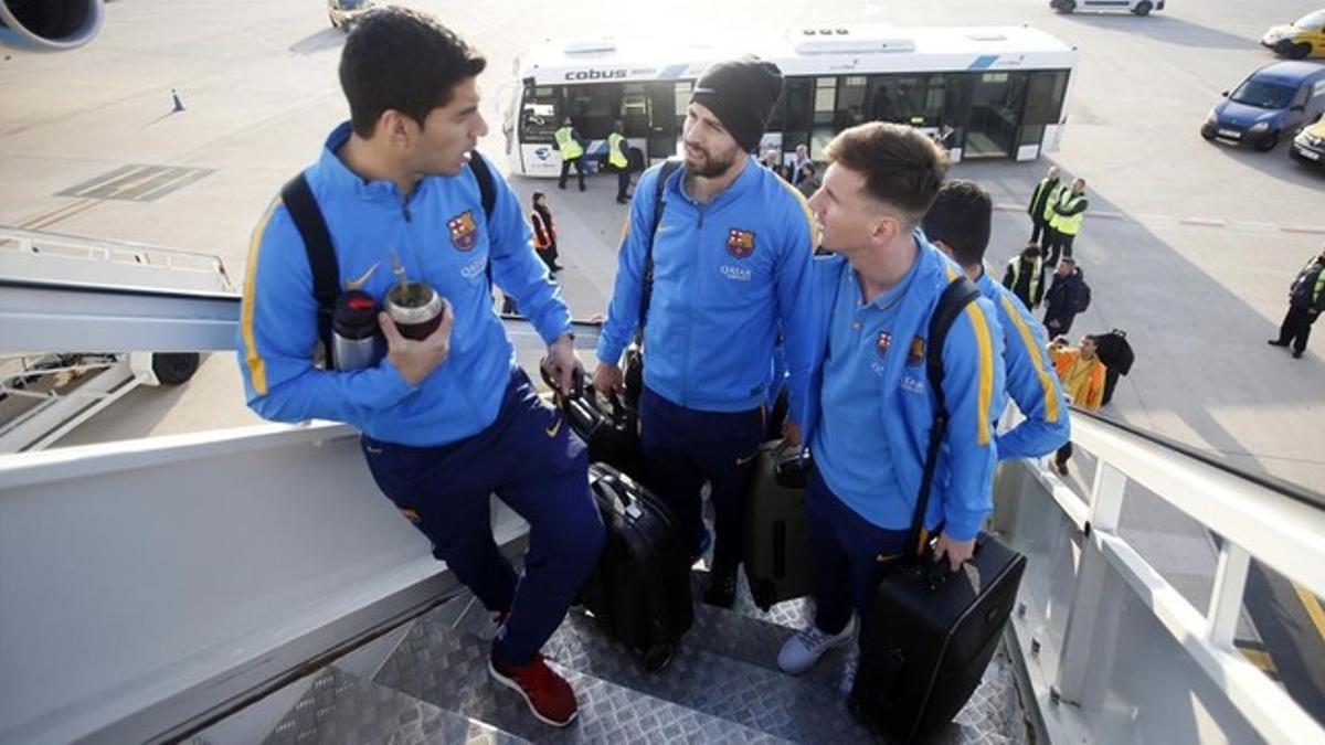 Suárez, Piqué y Messi suben al avión que tomó el Barça hacia Japón.