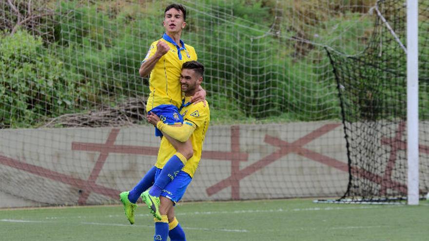 Benito sostiene a Carlos González, autor del segundo gol amarillo.