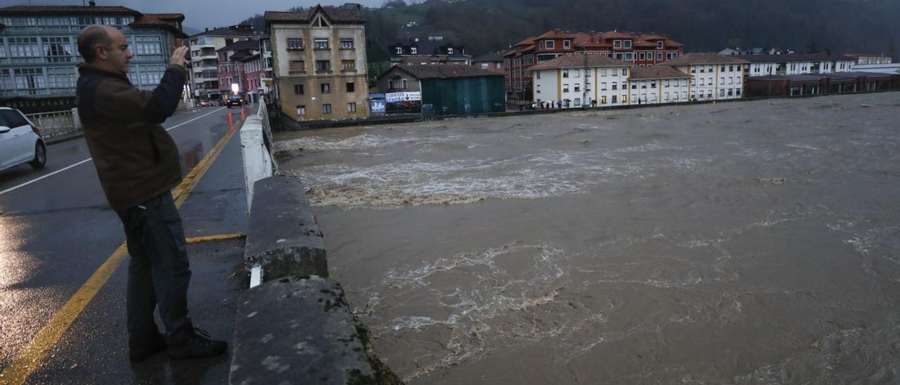 Un hombre fotografía la gran crecida del río Sella en Arriondas del pasado noviembre. | Luisma Murias