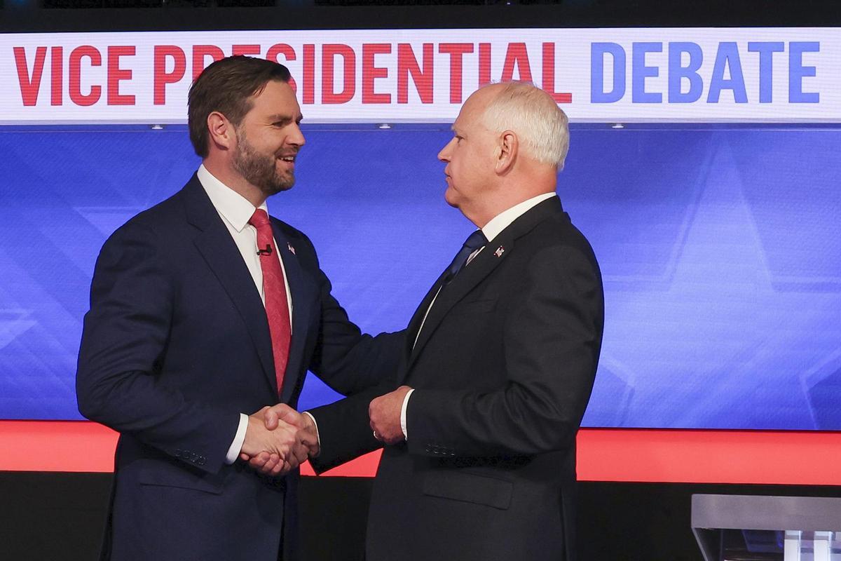 JD Vance (i) estrecha la mano de Tim Walz (d) antes del debate entre candidatos a vicepresidente de los EEUU.