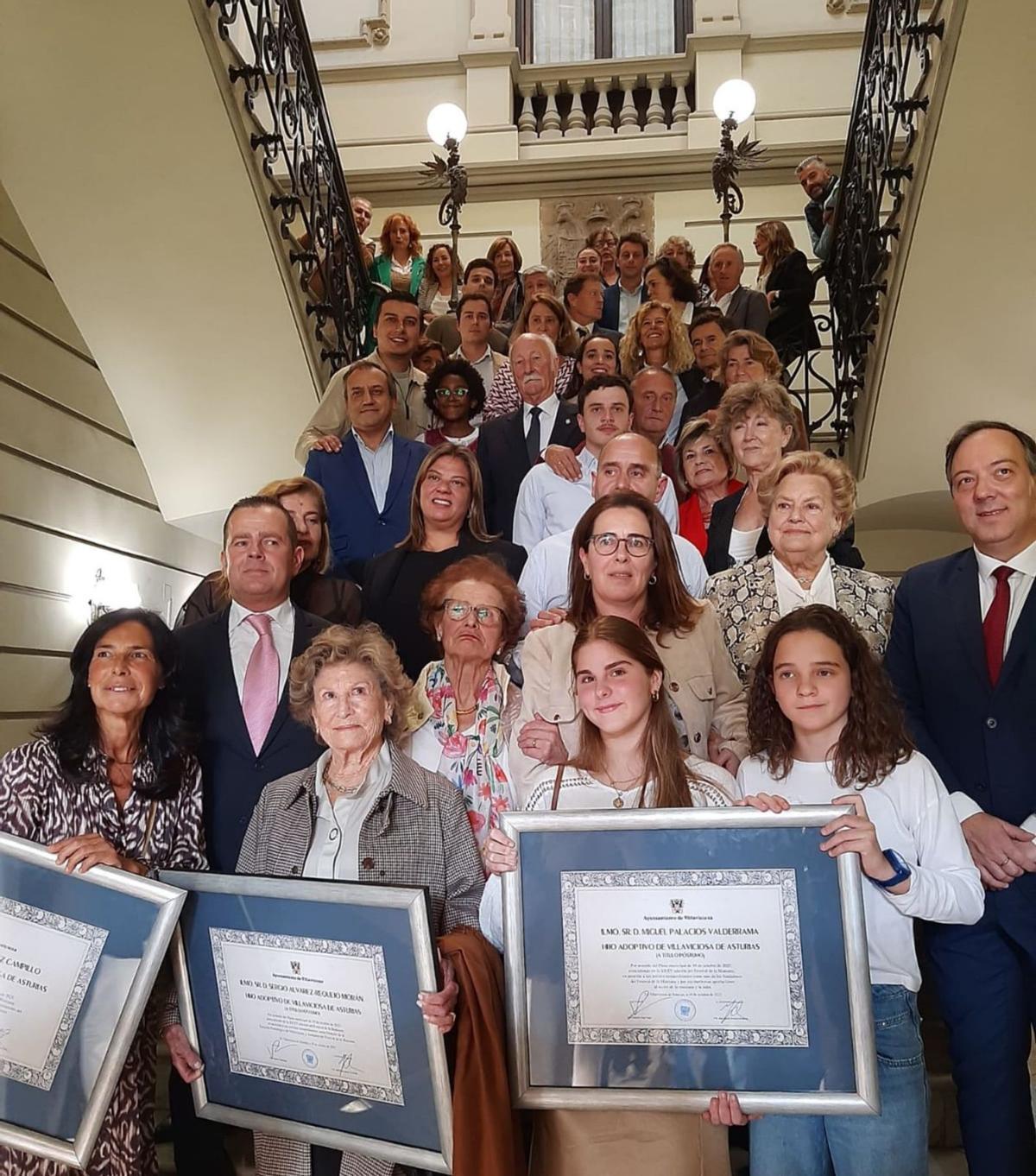 Foto de conjunto de los familiares de los galardonados y las autoridades políticas en el Ayuntamiento, tras el Pleno extraordinario. | L. P.