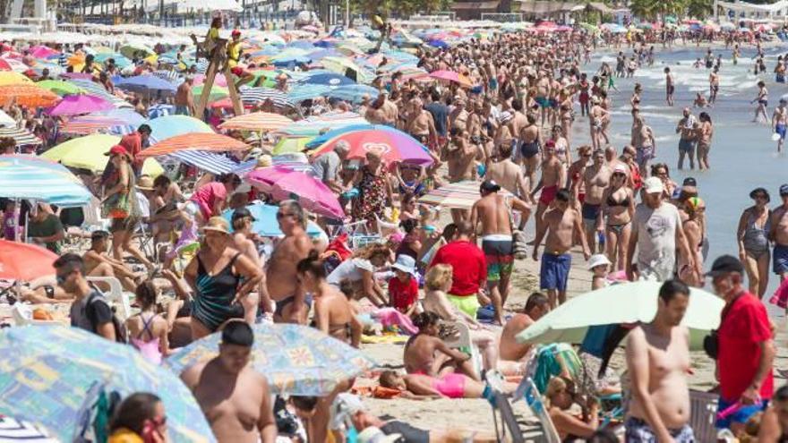 Playa del Postiguet de Alicante, totalmente abarrotada de bañistas ayer en torno a la una de la tarde, uno de los mayores momentos de afluencia del día.