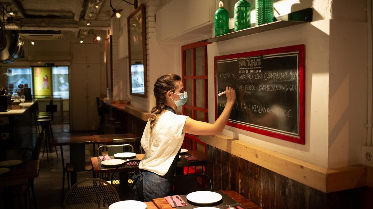 Una camarera trabaja en un bar en una calle céntrica de Barcelona.