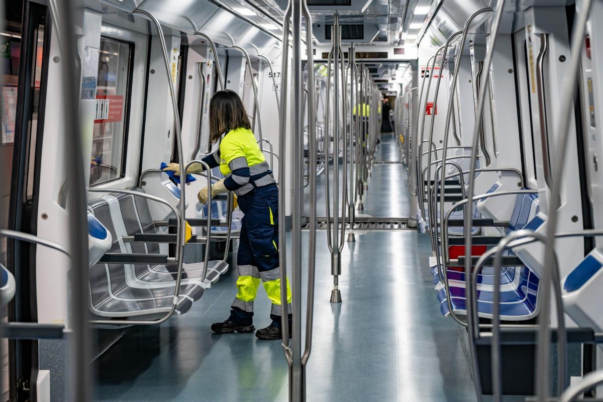 Una trabajadora limpiando un vagón de un tren del metro, en Barcelona.