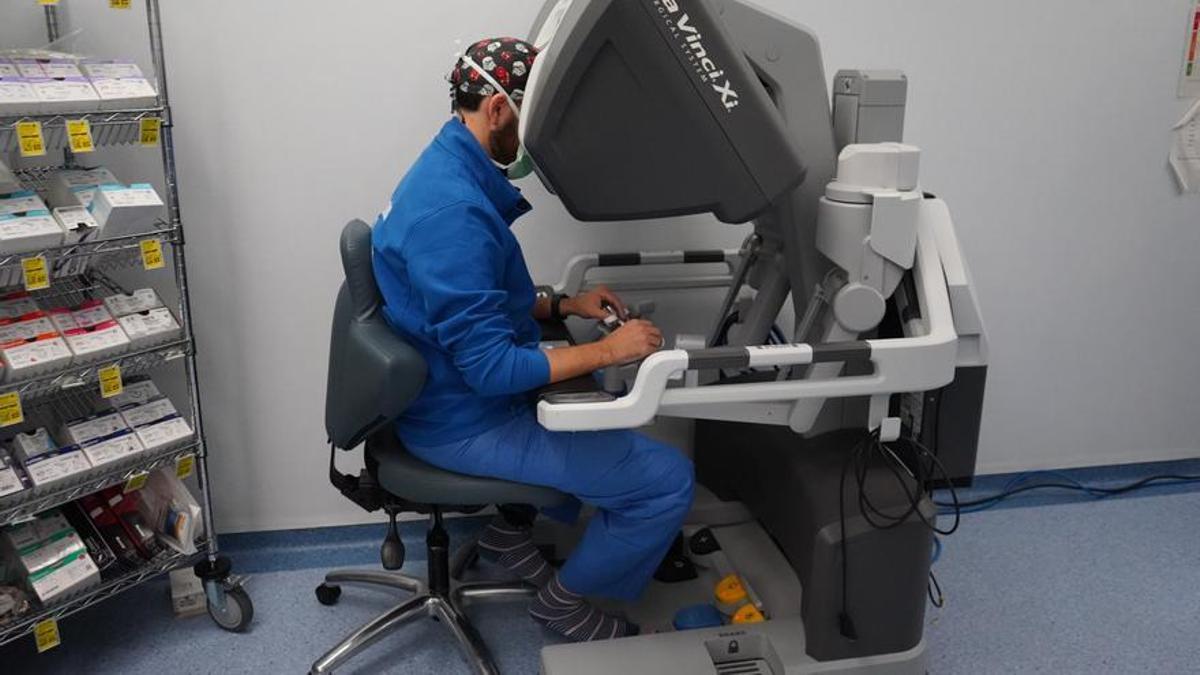 Un médico controla los brazos del robot durante el trasplante.