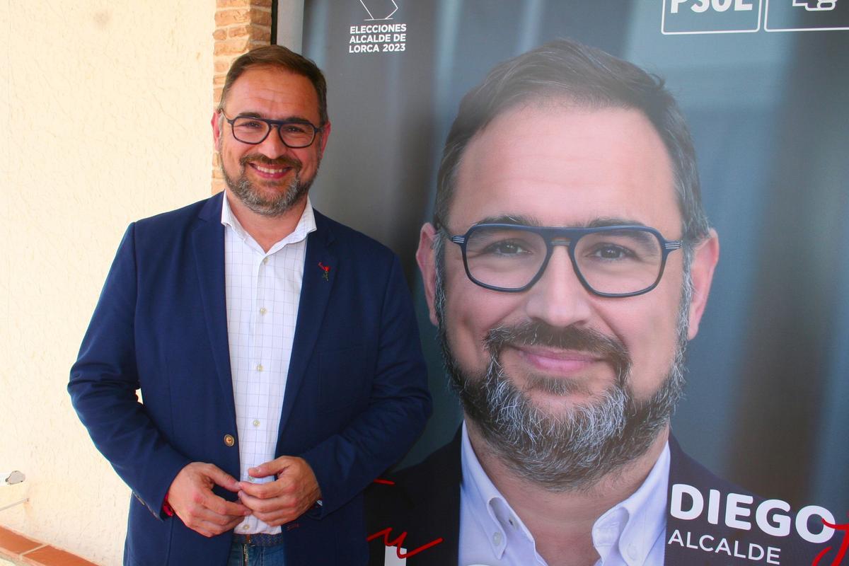 El candidato a la Alcaldía, Diego José Mateos, junto a uno de los carteles con su foto.