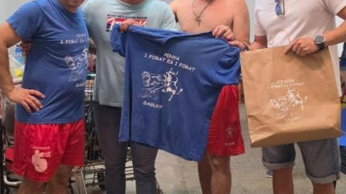 Camisetas y una bolsa con el logo de la peña.