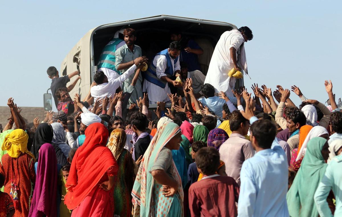 Sehwan (Pakistan), 01/09/2022.- People affected by floods receive aid in Sehwan, Sindh province, Pakistan, 01 September 2022. According to the National Disaster Management Authority (NDMA) on 27 August, flash floods triggered by heavy monsoon rains have killed over 1,000 people across Pakistan since mid-June 2022. More than 33 million people have been affected by floods, the country’s climate change minister said. (Inundaciones) EFE/EPA/REHAN KHAN