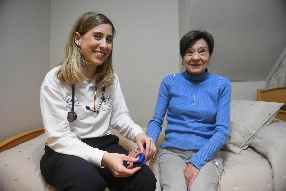 La doctora Lara Otero, de Hospitalización a Domicilio (HADO) del Chuac, junto a una de sus pacientes, María, en su casa de Oleiros.