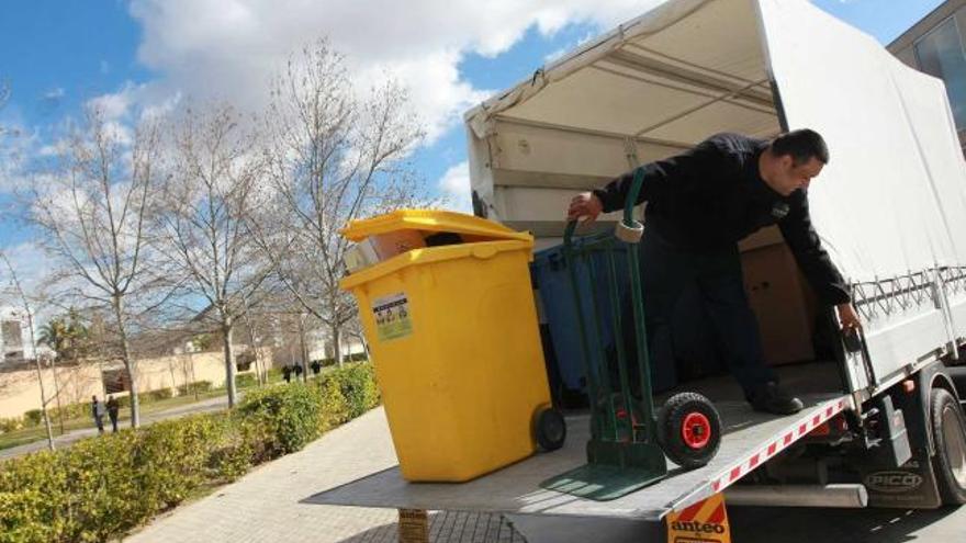 Uno de los operarios de la Universidad de Alicante descarga de un camión unos de los contenedores de reciclaje que forman parte de la Agenda 21.