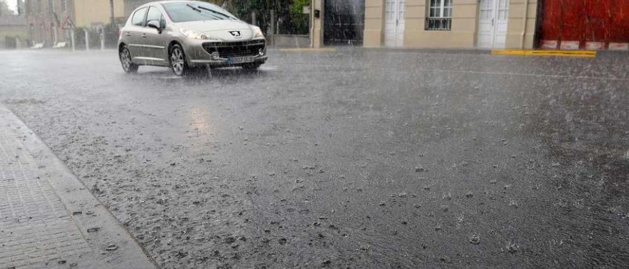 Jornada otoñal en pleno mes de junio | Con una temperatura máxima de 11 grados y lluvias que alcanzaron los 14,6 litros por metro cuadrado en la estación climática de Vilarmaior (Rodeiro). Así transcurrió la jornada de ayer, entre trombas de agua e incluso amagos de tormenta que permitieron treguas muy leves para que el sol luciese entre las nubes. Según las previsiones de Meteogalicia, el tiempo veraniego se instalará en la comarca a partir del lunes. En la imagen, un coche circula bajo la lluvia en A Bandeira.