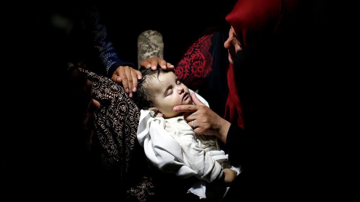 Familiares ante el cuerpo de la niña palestina Laila al-Ghandour, de ocho meses, que murió después de inhalar gas lacrimógeno durante una protesta contra el traslado de la embajada estadounidense a Jerusalén en la frontera entre Israel y Gaza.