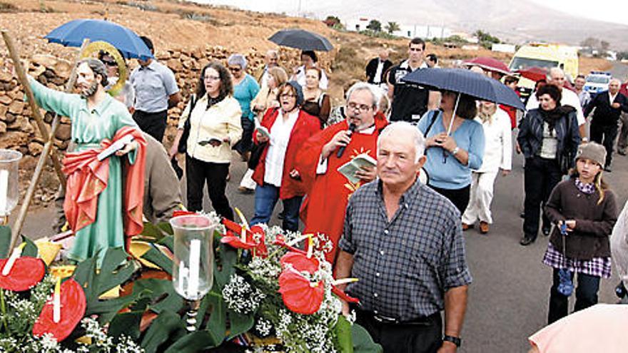 Los vecinos de Tetir, algunos con paraguas, trasladan a San Andrés hasta la ermita de La Sargenta.  FUSELLI