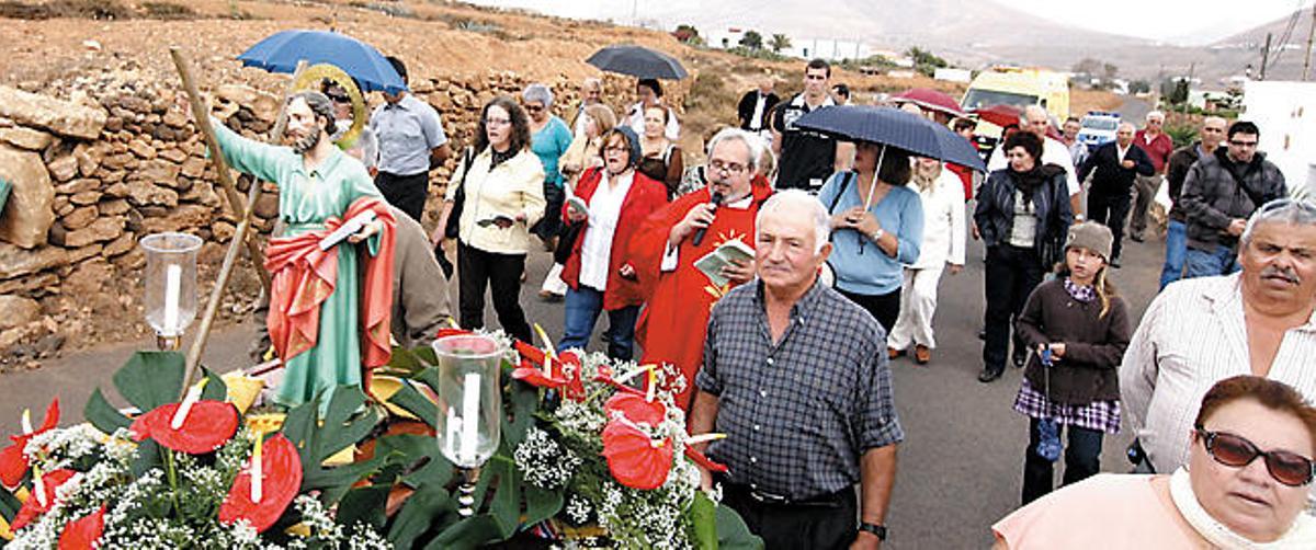 Los vecinos de Tetir, algunos con paraguas, trasladan a San Andrés hasta la ermita de La Sargenta.  FUSELLI