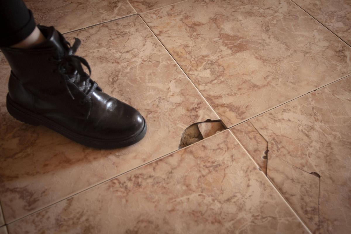 Una vecina muestra los desperfectos del edificio donde vive, unos causados por la aluminosis en Mislata.