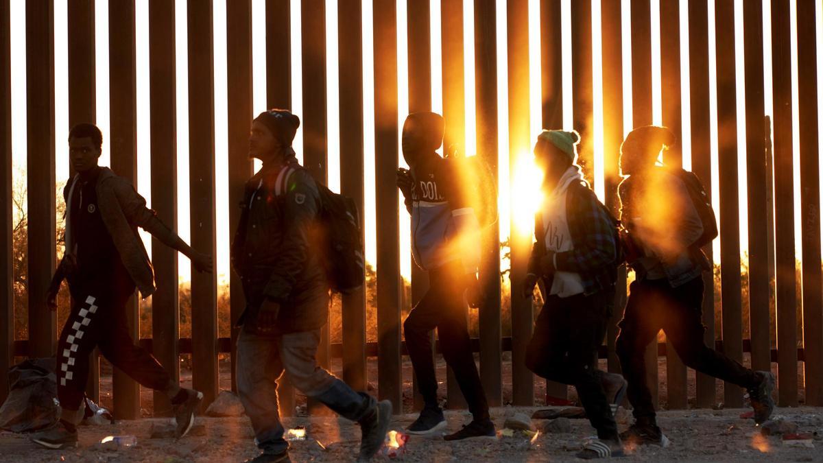 Un grupo de migrantes africanos camina junto al muro de la frontera de México y Estados Unidos, en la localidad de Lukeville.