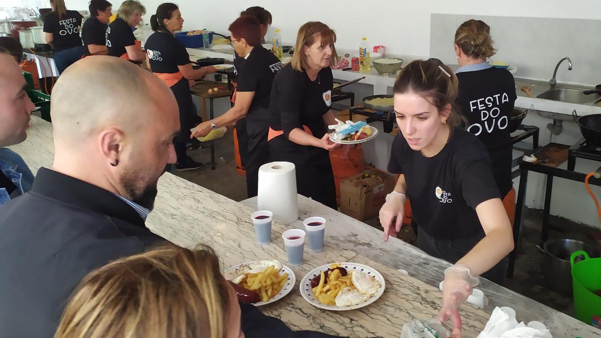 Unas personas adquieren sus raciones, ayer en la fiesta. / Antonio Pinacho