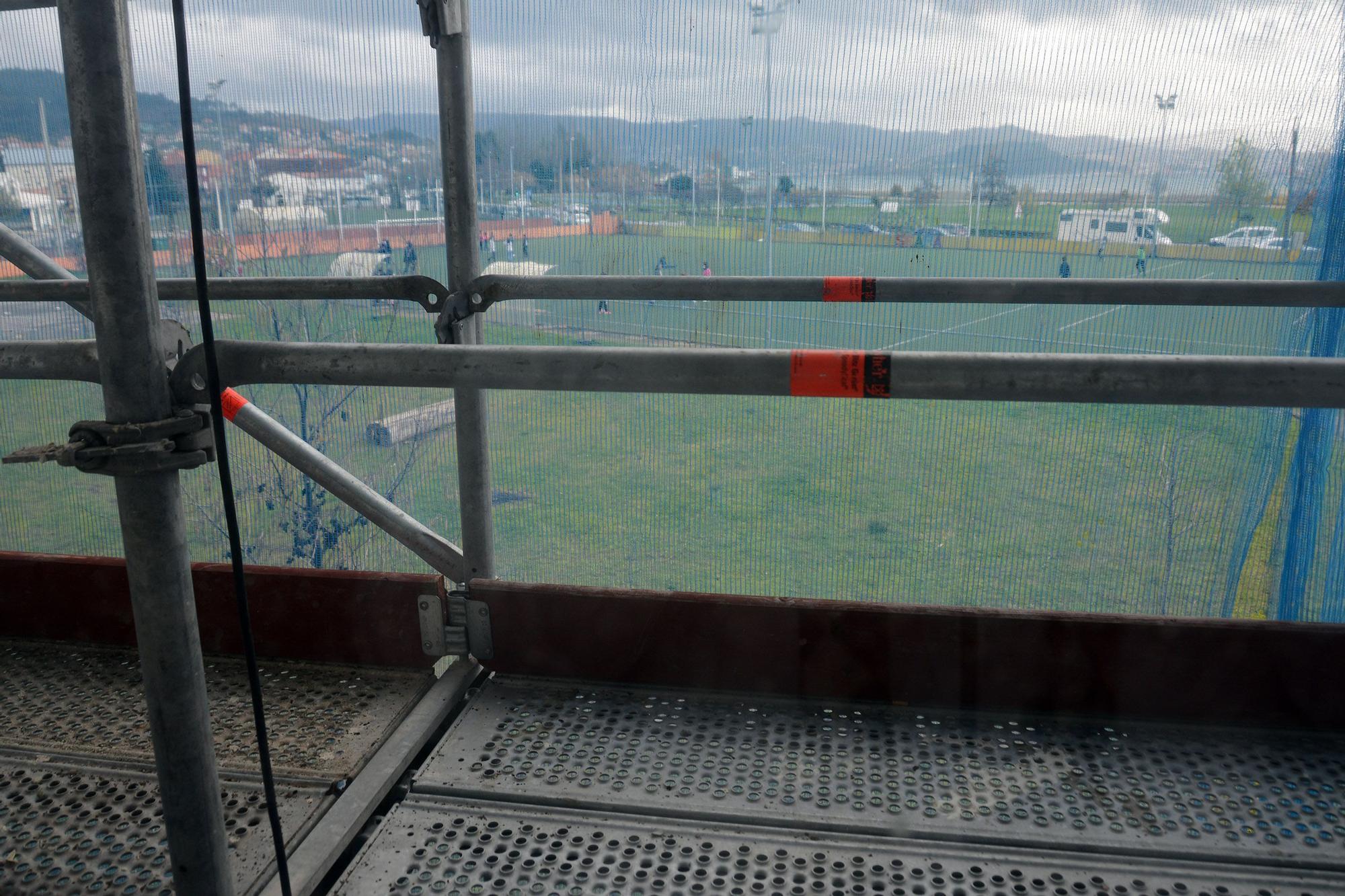 Pequeños jugando en el patio, vistos a través del andamio.