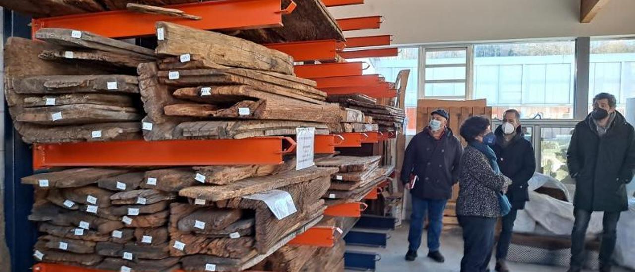 Algunas de las maderas de hórreo apiladas en el Centro de la Madera, durante la visita de la Consejera Berta Piñán y miembros de Amigos del Hórreo Asturiano.