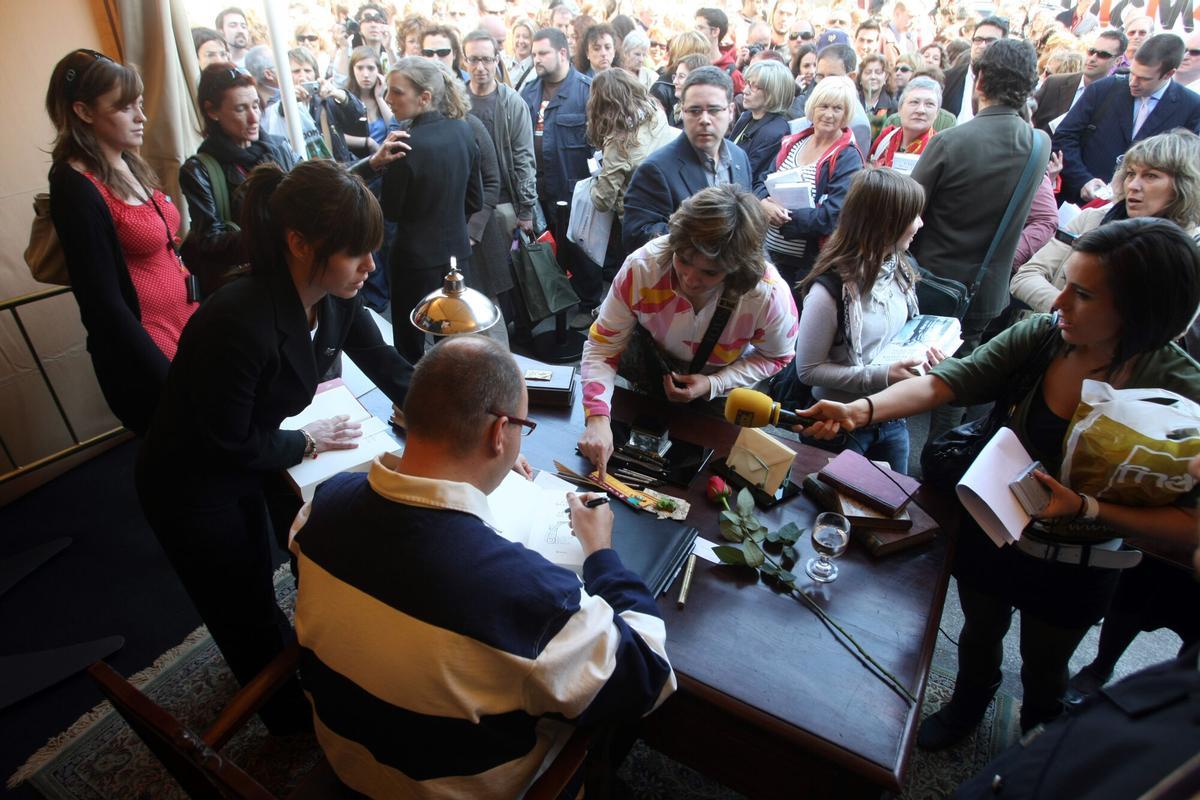 BARCELONA 23/4/2008 DIA DE SANT JORDI CARLOS RIUZ ZAFON EN LA CASETA DONDE HA FIRMADO LIBROS EN LA GRAN VIA CON PASSEIG DE GRACIA CON GRANDES COLAS DE 3 HORAS DE ESPERA FOTO DE JULIO CARBO. FIESTAS POPULARES , ABRIL , FIESTA DE SANT JORDI , DIA DEL LIBRO 2008 , AMBIENTE CALLE , GENTE , COLAS DE ESPERA , ESCRITORES ,ESCRITOR , ESCRITORA , FIRMA EJEMPLARES , CARLOS RUIZ ZAFON _ GENERAL, PLANO