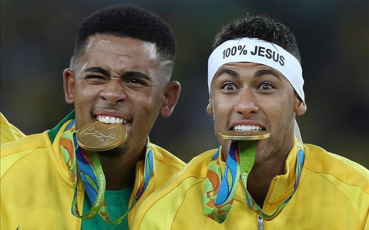 Gabriel Jesús y Neymar con sus medallas de oro entre sus dientes