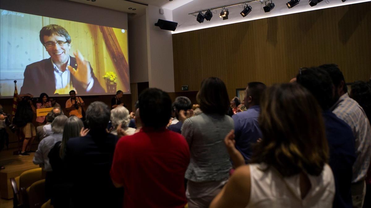 Carles Puigdemont saluda, a través de una pantalla, a los asistentes a la presentación de Crida Nacional per la República.