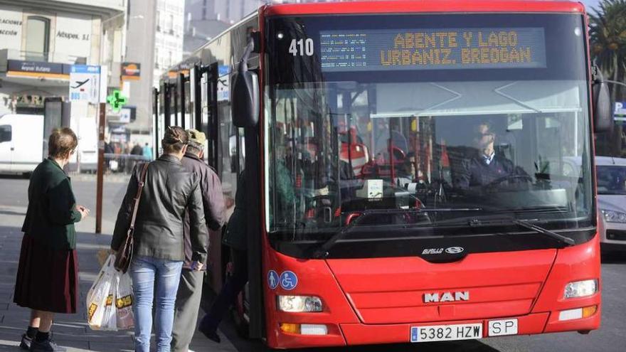 Usuarios del autobús urbano se suben a un vehículo en la parada de la plaza de Ourense.