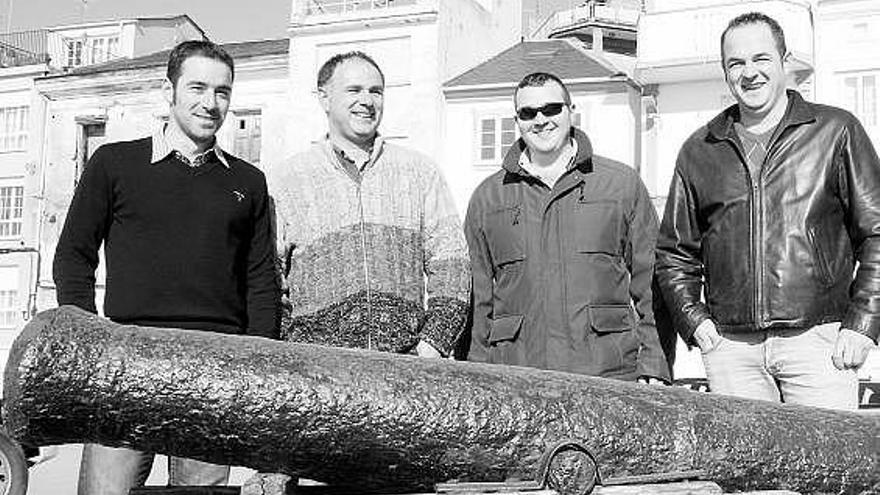 Los buzos del club Figas junto a un cañón que decora el muelle de Figueras.