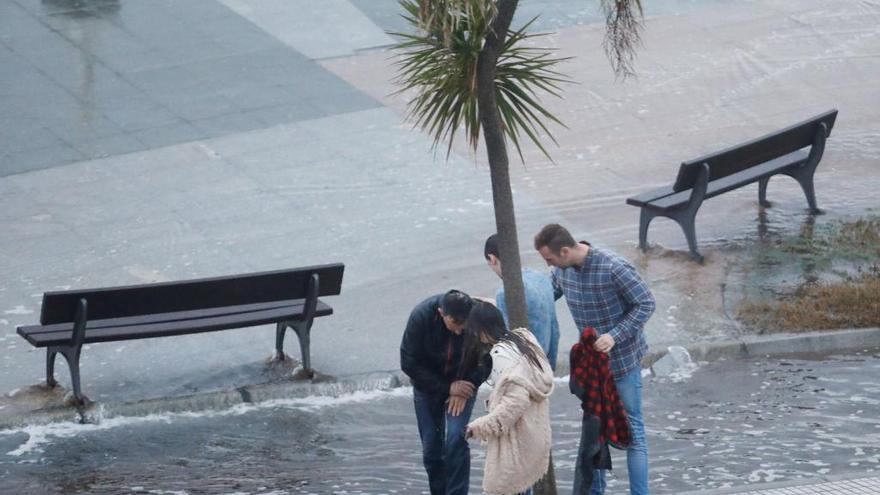 Los riesgos del temporal en Gijón: Un hombre se rompe la muñeca tras derribarle una ola