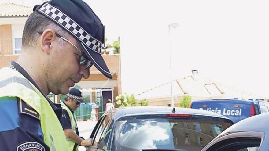 Dos agentes realizando pruebas de alcoholemia en un control.