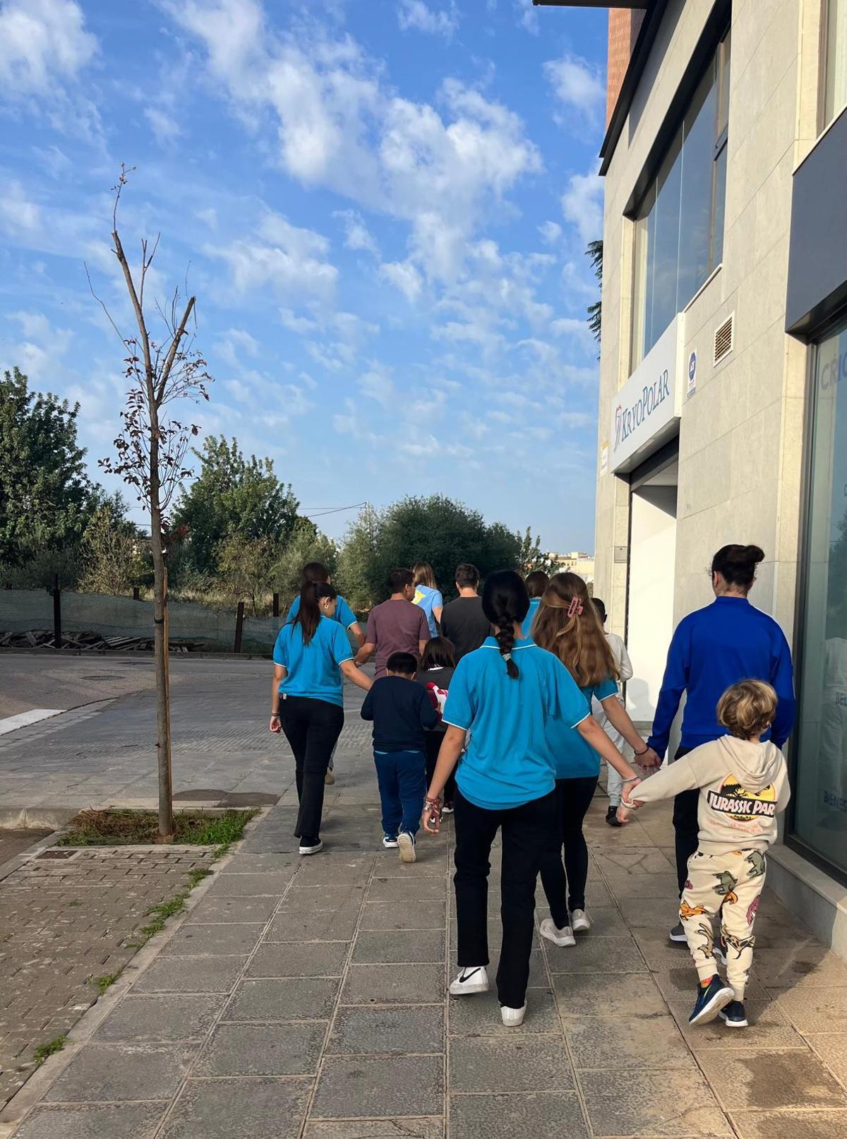 Trabajadoras, voluntarios y niños, dando un paseo, en Torrent tras la dana