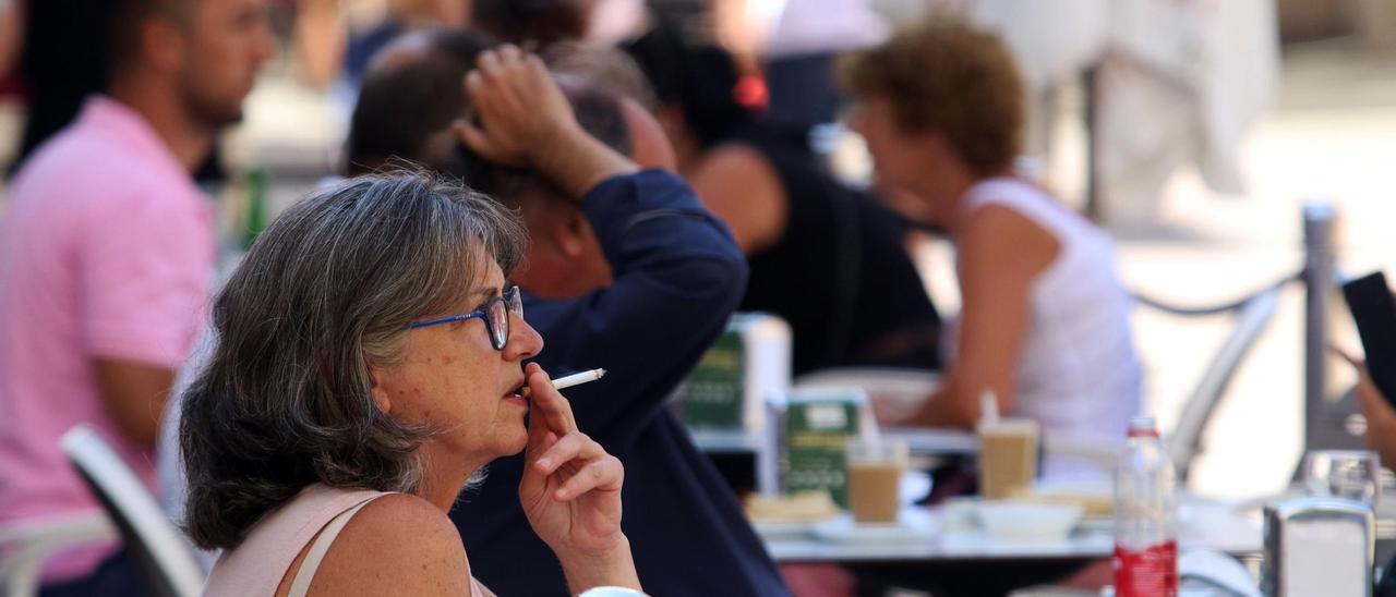 Una mujer fuma en la terraza de un bar