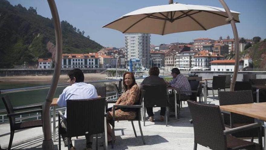 Varios clientes del Náutico disfrutan de su terraza con vistas al mar y a la villa de Candás.
