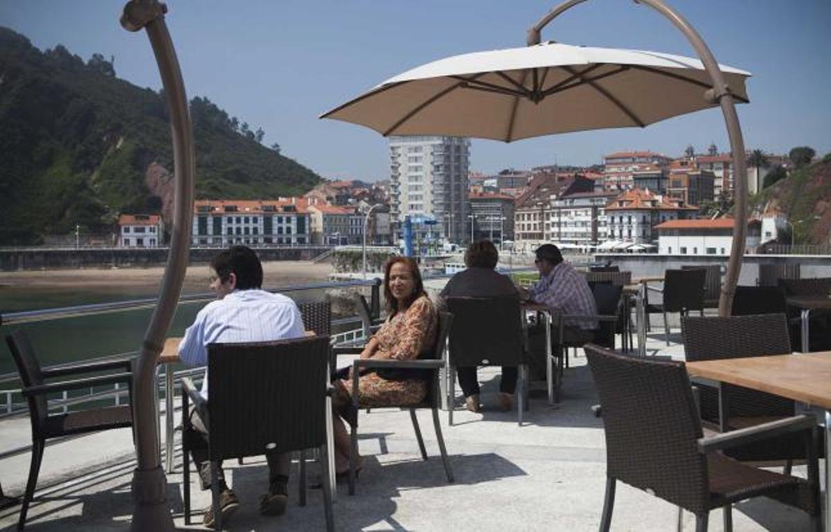 Varios clientes del Náutico disfrutan de su terraza con vistas al mar y a la villa de Candás.