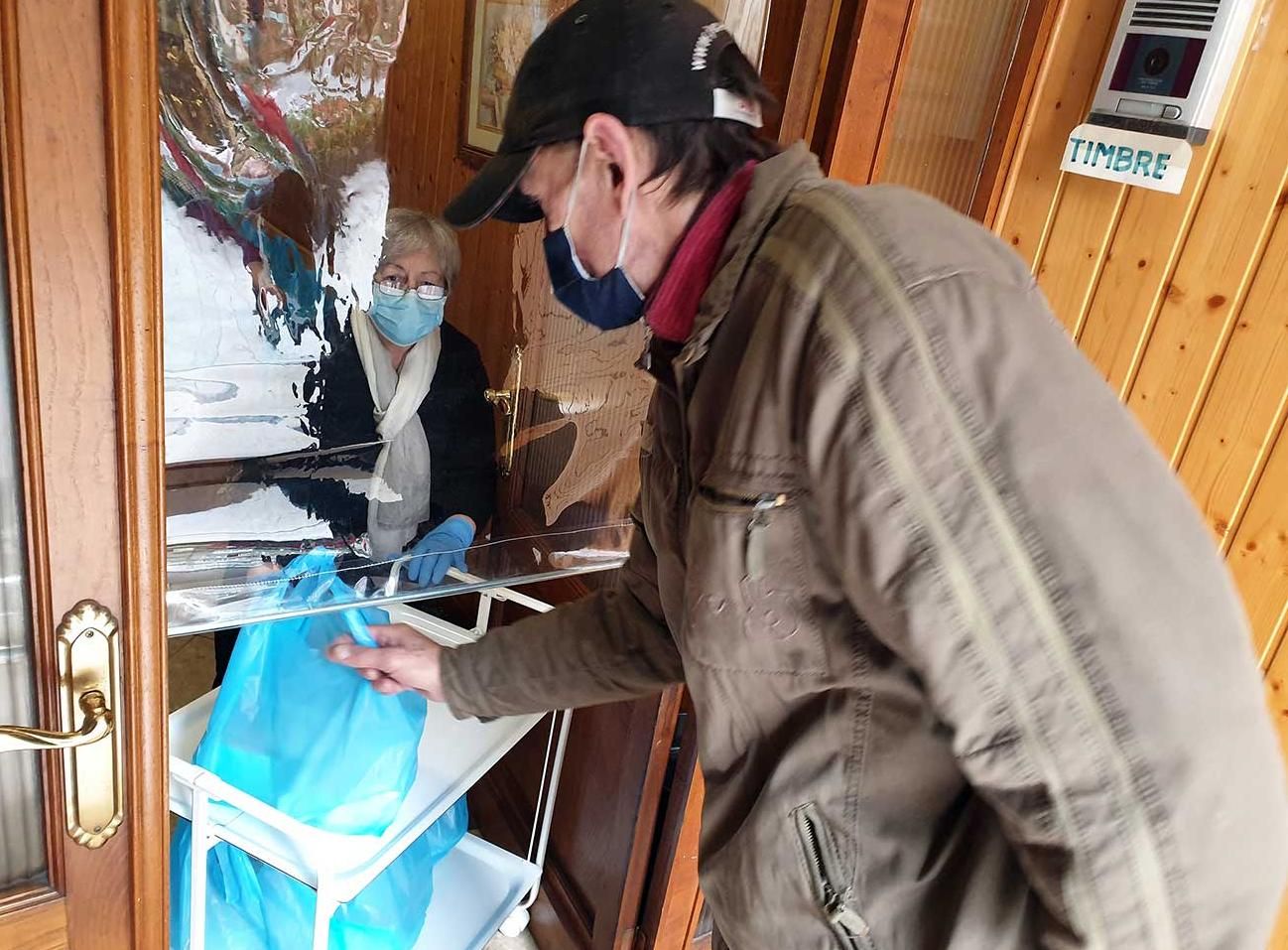 Un pobre recoge una bolsa de comida en la Misión del Silencio.