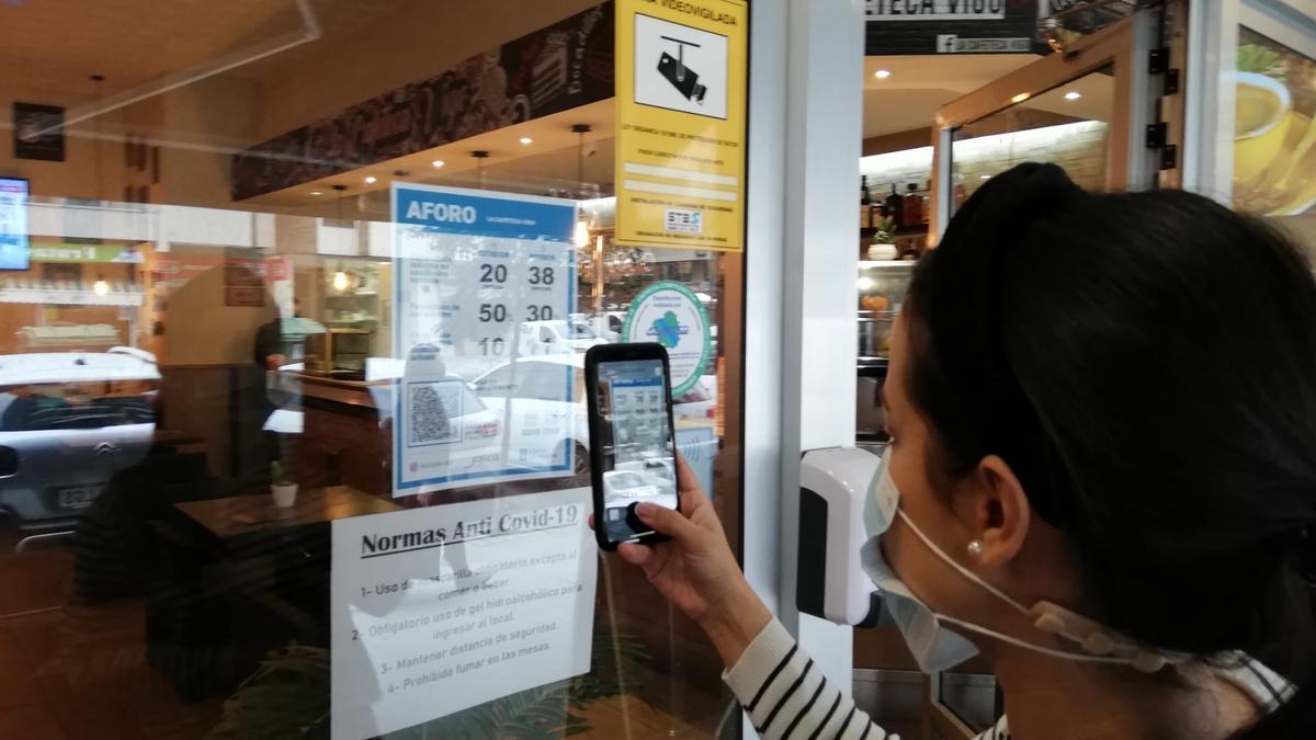 Una clienta de un bar de Rosalía de Castro escanea el código QR