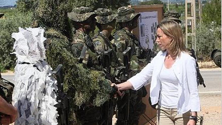 La ministra de Defensa estrecha la mano a un militar con un traje de camuflaje.