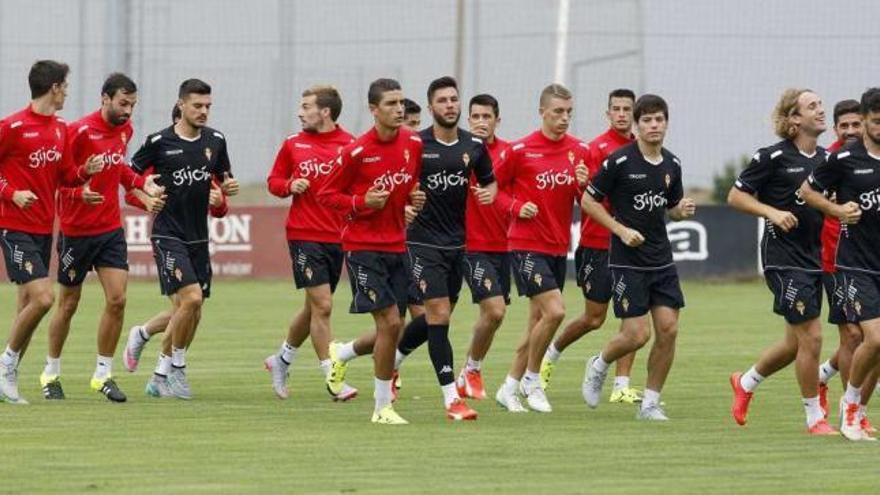 Los jugadores del Sporting, realizando ejercicios de calentamiento durante el entrenamiento de ayer.