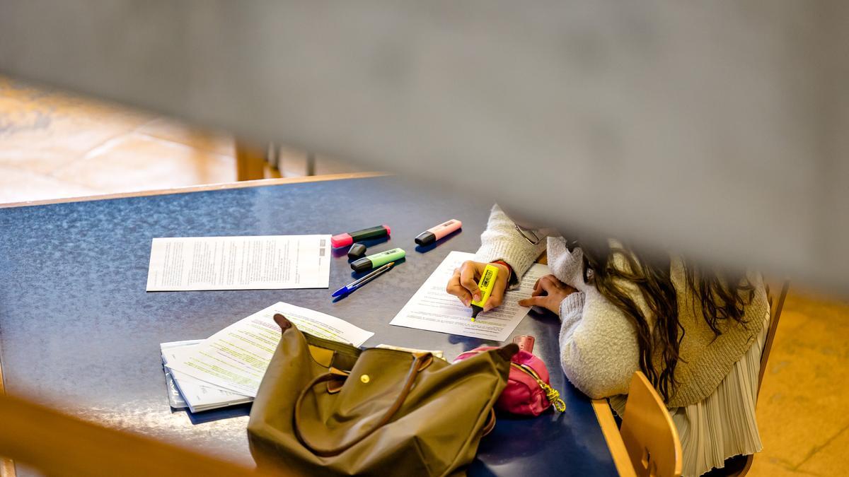 Una joven subraya unos apuntes en la universidad.