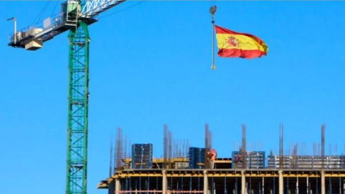 Una bandera de España siendo colocada en lo alto de una obra /