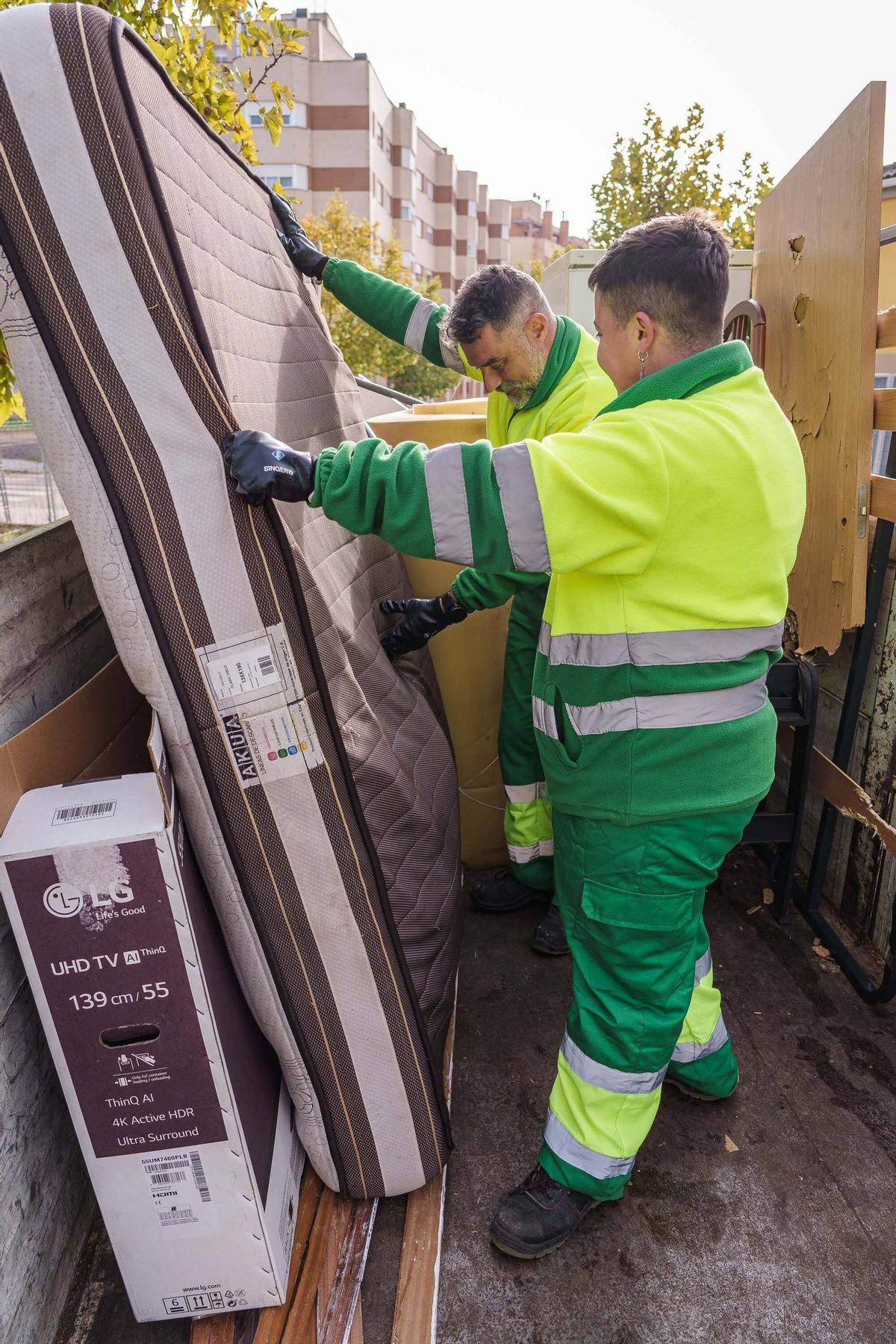 Alfonso Pino y Nera Sanguino colocan los enseres en el camión de recogida.
