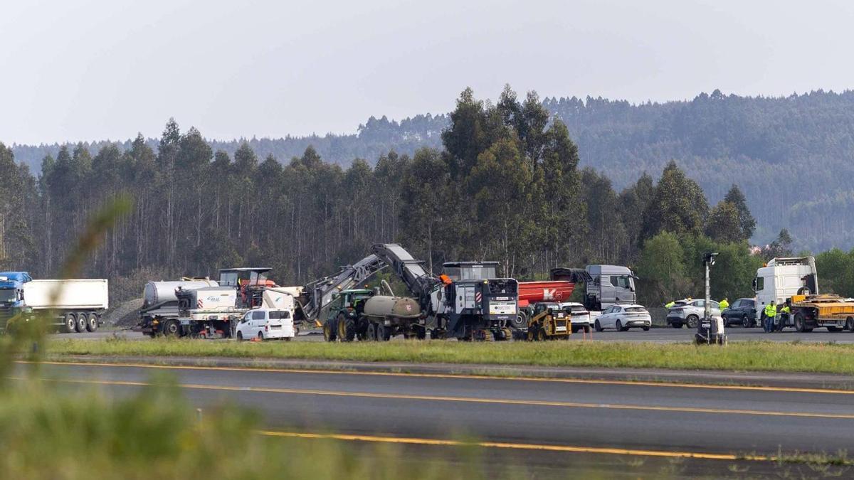 Operarios y maquinaria trabajando sobre la pista de aterrizaje del aeropuerto de Santiago.