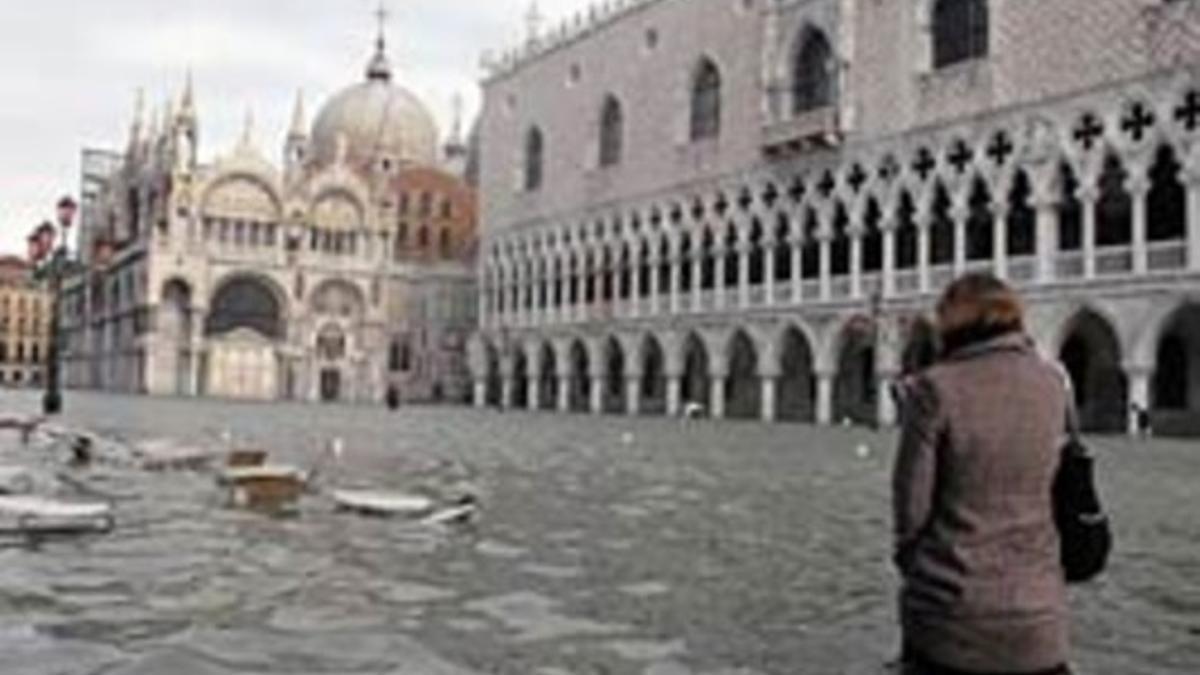Una mujer camina por la plaza de San Marco de Venecia, totalmente anegada, esta mañana.