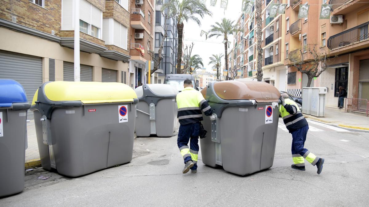 Operaris de Paiporta  ubiquen un dels  contenidors marrons.