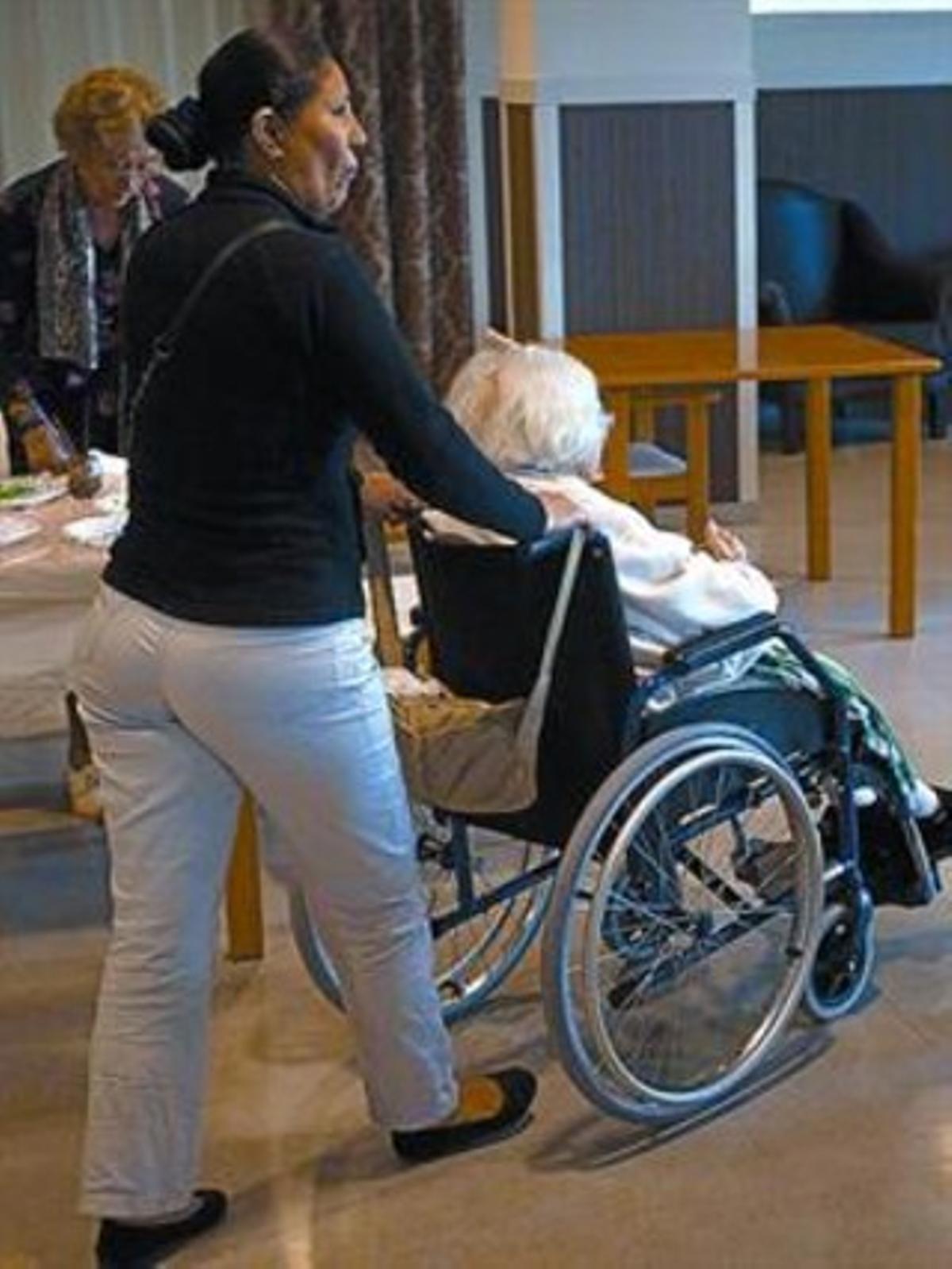 Una anciana y su cuidadora, en un geriátrico.