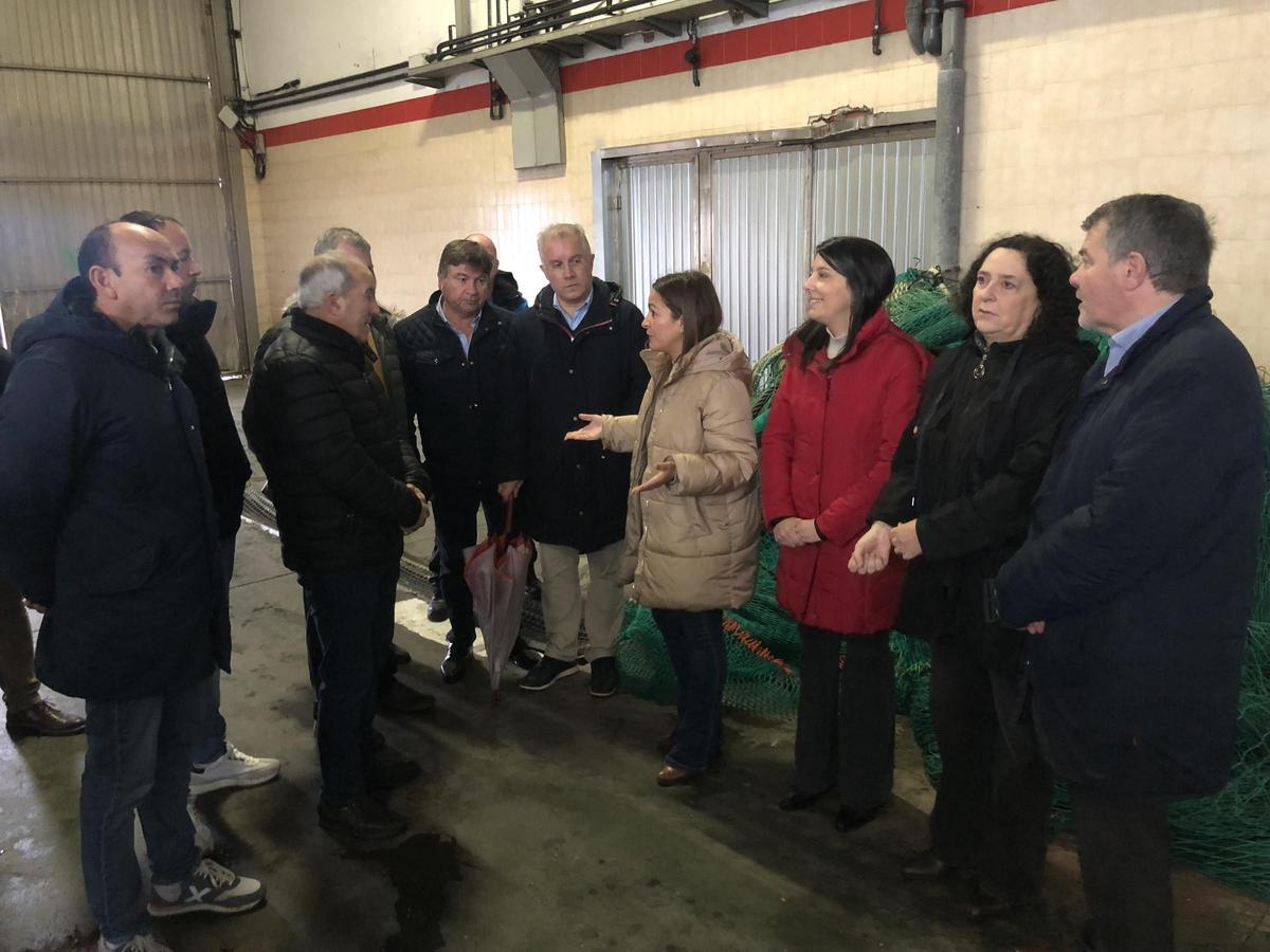 Francisco Argibay, segundo por la izquierda, ayer conversando con la conselleira de Mar, Marta Villaverde, en la antigua lonja de Ribeira.