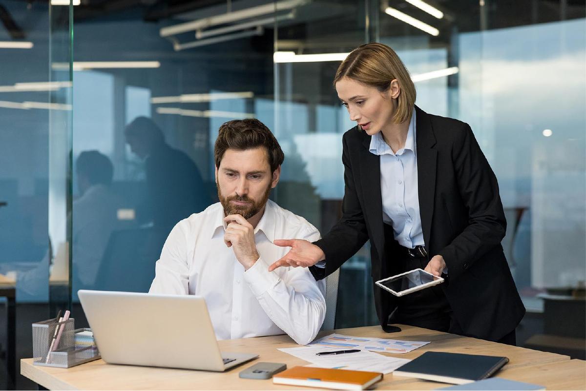 Dos professionals analitzen informació en una reunió empresarial