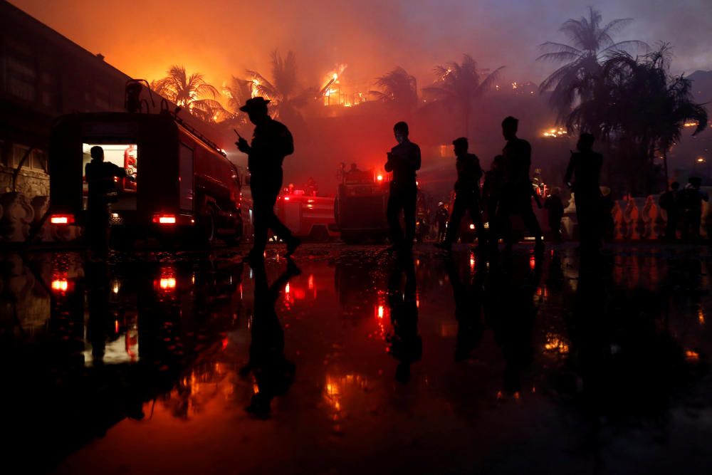 Police officers stand guard during a fire at ...