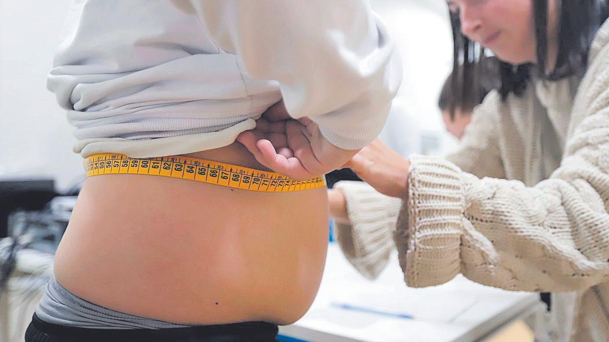 Una pediatra mide el perímetro abdominal de un niño. | A. J. González