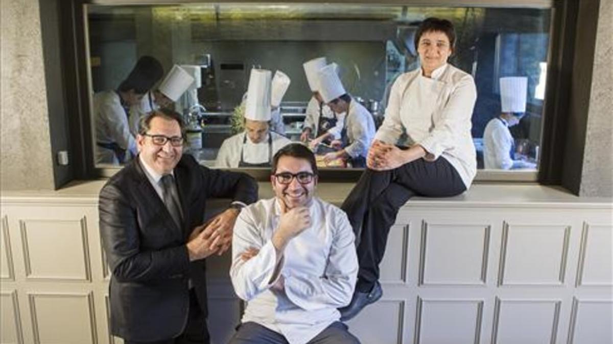 Joan, Jordi e Isabel Junca, ante la cocina de Ca l'Enric, en la Vall de Bianya.